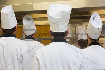 Five chefs standing in a kitchen