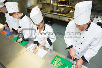 Four chefs preparing food at counter