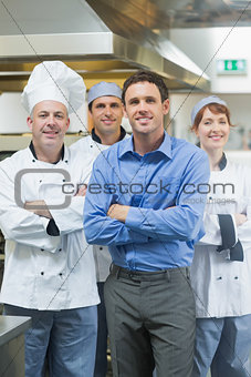 Handsome manager posing with some chefs