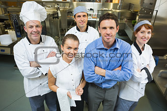 Handsome manager posing with some chefs and waitress