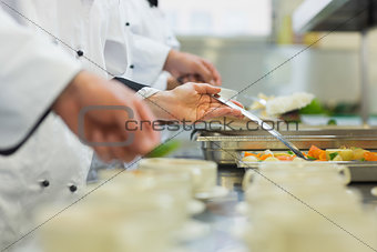 Chefs standing in a row preparing food