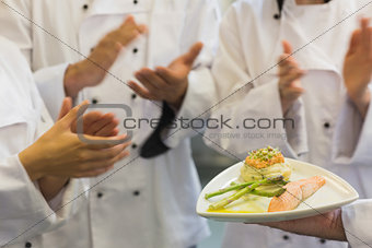 Chefs applauding a salmon dish