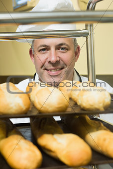 Happy head chef pushing a trolley with baguettes on it