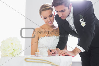 Handsome bridegroom signing wedding contract