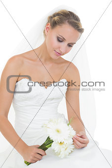 Lovely thoughtful bride sitting on ground
