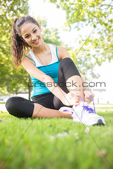 Cheerful active brunette tying her shoelaces