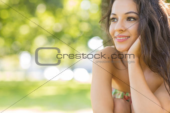 Stylish beautiful brunette sitting under a tree