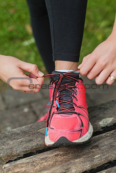 Close up of young woman tying her shoelaces