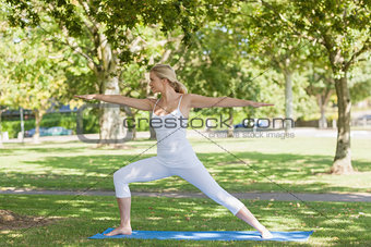 Side view of beautiful fit woman stretching in yoga pose