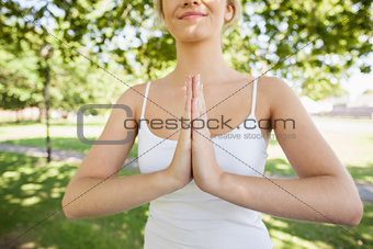 Mid section of content calm woman meditating in a park