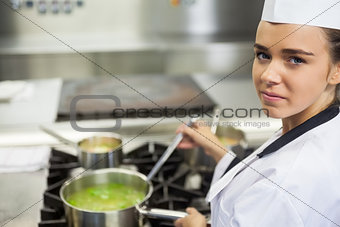 Young happy chef stirring sauce