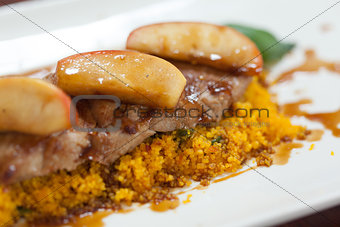 Close up of couscous with meat garnished with apple