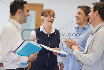 Group of mature students standing in classroom chatting