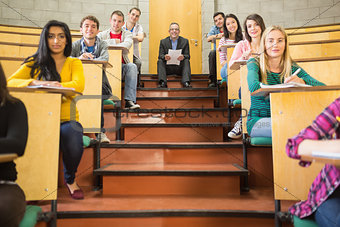 Rlegant teacher with students sitting at the lecture hall