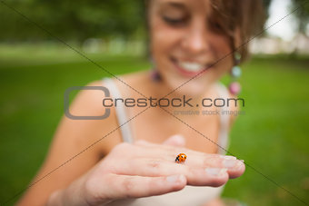 Close up of a blurred woman gently holding a ladybug