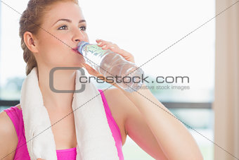 Woman drinking water in fitness studio