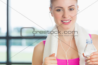 Woman holding water bottle in fitness studio