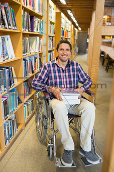 Man in wheelchair by bookshelf in library