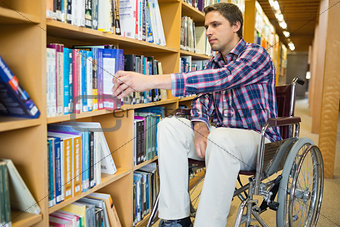Disabled wheelchair selecting book in library