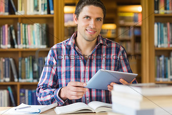 Mature student holding tablet PC in the library
