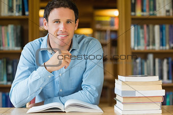 Smiling mature student studying at library desk
