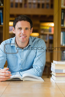 Smiling mature student studying at library desk