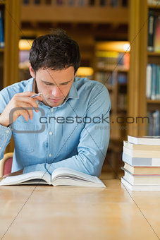 Serious mature student studying at library desk