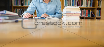 Mid section of a student studying at library desk