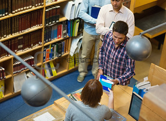 Mature students at counter in college library
