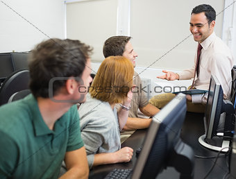 Teacher and mature students in computer room