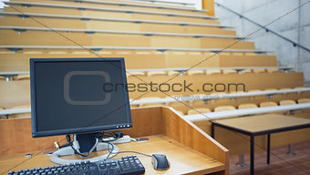 Computer monitor with empty seats in a lecture hall