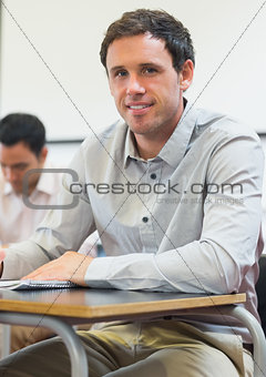 Portrait of a mature student taking notes in classroom