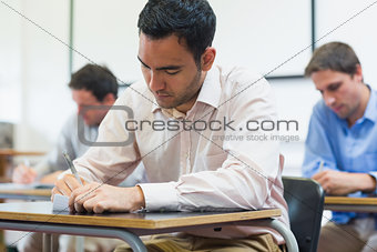 Mature students taking notes in classroom