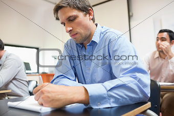 Mature students taking notes in classroom