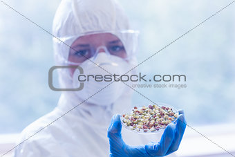 Scientist in protective suit with sprouts