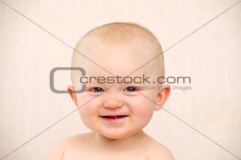 Baby looking at the camera on a peach background