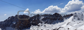 Panorama of snowy mountains in spring sunny day