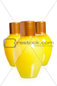 three yellow bottles of cosmetics