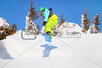 Snowboarder jumping on mountain slope
