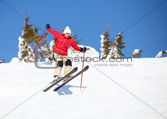 Young female skier jumping on snowy slope