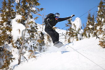 Snowboarder jumping on mountain slope