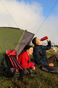 Young couple with a tent in the mountains