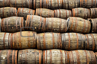 Stacked pile of old whisky and wine wooden barrels