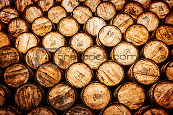 Detail view of stacked whisky and wine wooden barrels