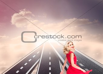 Blonde woman wearing red dress and twirling