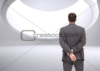 Businessman standing with hands behind back