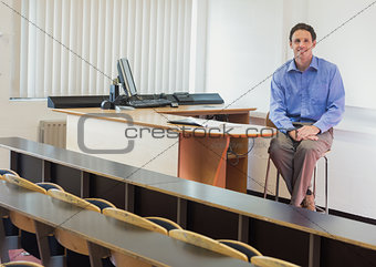 Elegant male teacher sitting in the lecture hall