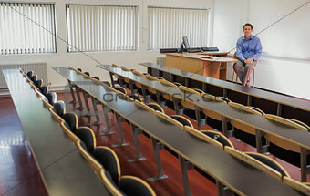 Elegant male teacher sitting in the lecture hall