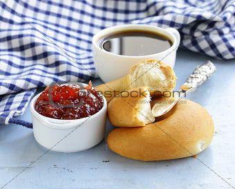 strawberry jam and bread rolls with a cup of coffee