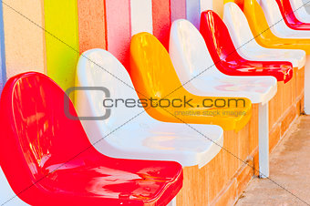 a number of multi-colored seats for children
